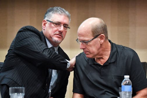 Attorney Michael Padden, left, patted his client Dan Rassier at a press conference at the Marriott Northwest Hotel in Brooklyn Park on Nov. 22, 2016.