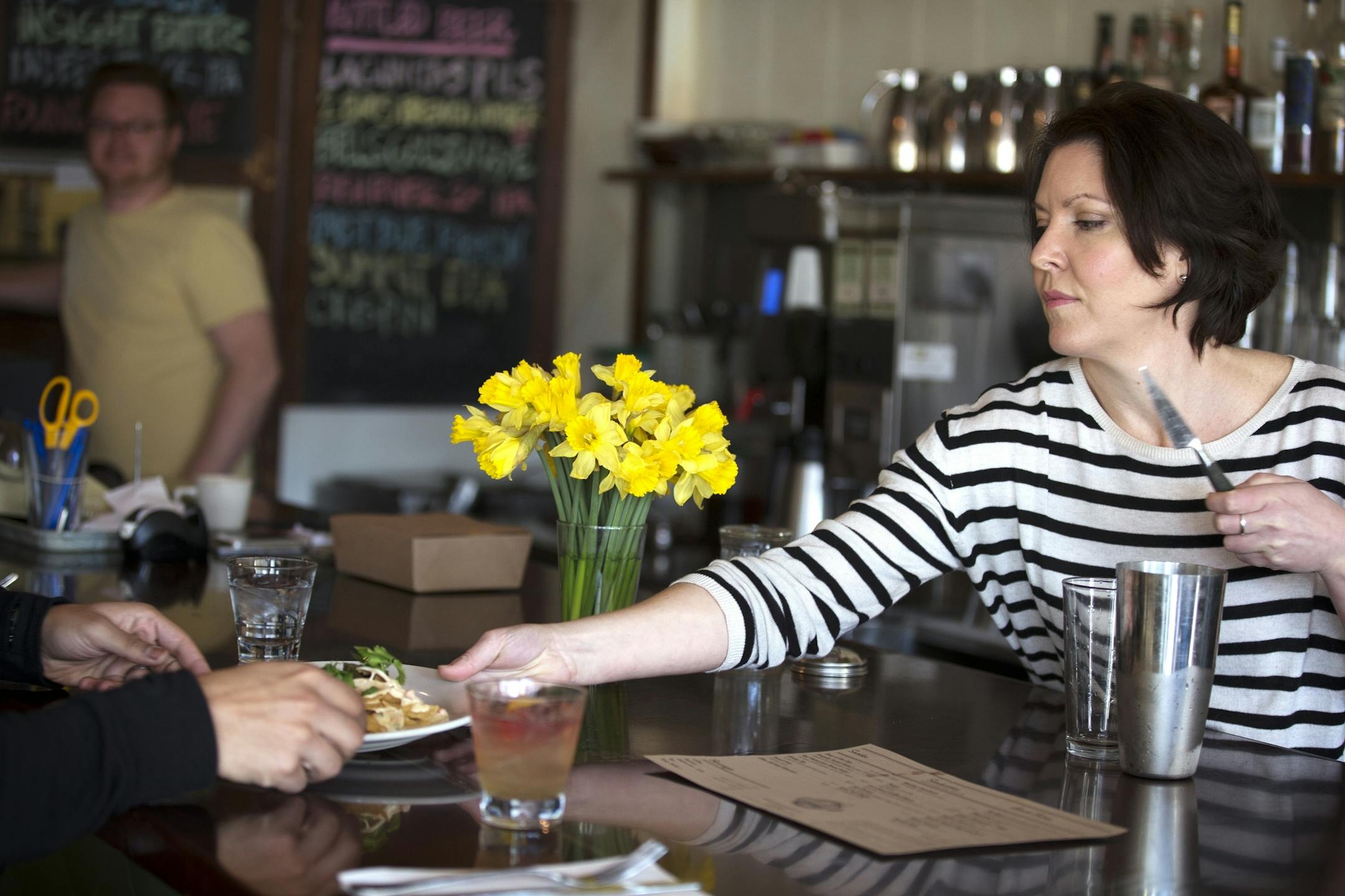 Server/bartender Raleigh Phillips, who has worked there over ten years, serves food to a customer at the Modern Cafe in Minneapolis on Tuesday, March 10, 2015.