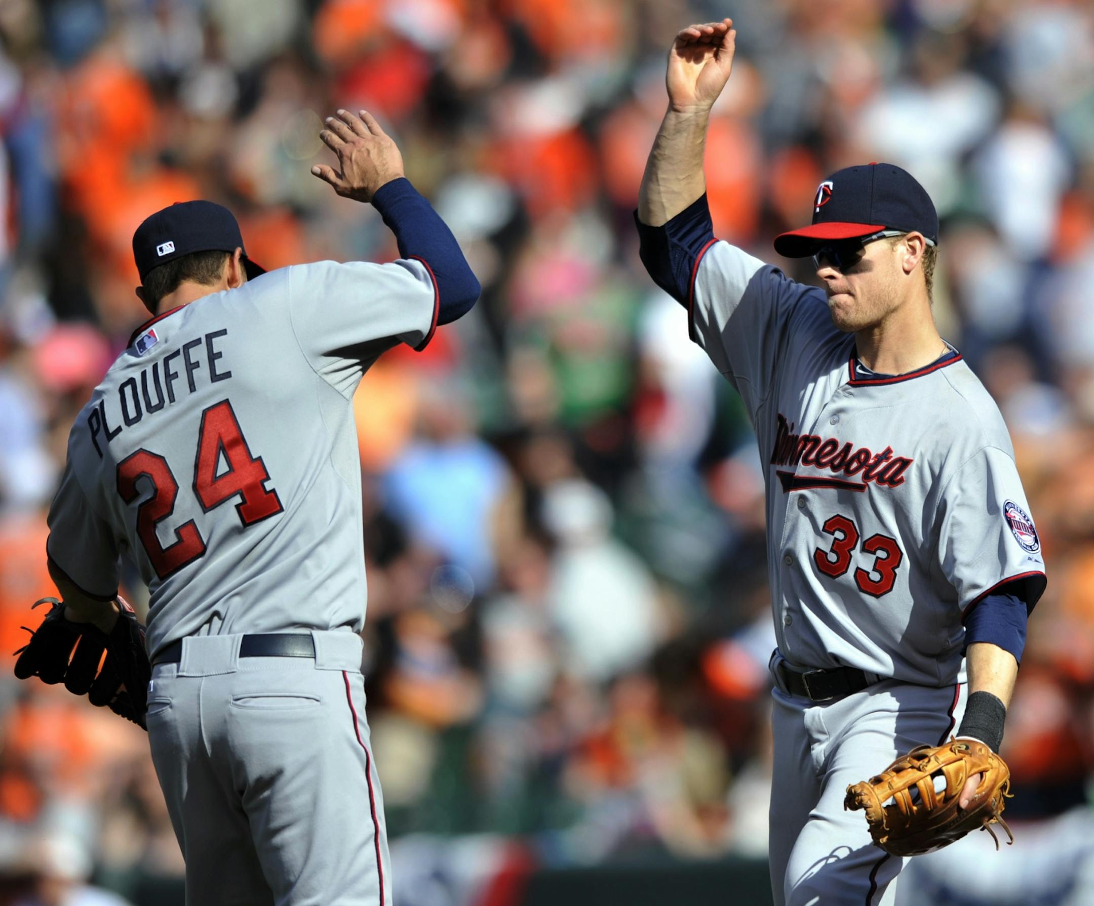 Minnesota Twins' Justin Morneau, right, and Trevor Plouffe celebrate their 4-3 win over the Baltimore Orioles.