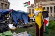 Student Eleanor Wirtz, 21, carefully folds up a Palestinian flag as she and other protesters clear the encampment at the University of Minnesota on Th