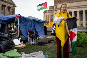 Student Eleanor Wirtz, 21, carefully folds up a Palestinian flag as she and other protesters clear the encampment at the University of Minnesota on Th