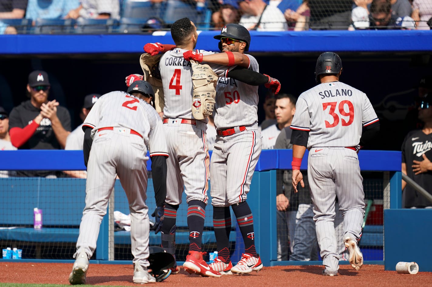 Carlos Correa celebrates with his teammates after hitting a grand slam against the Blue Jays during the eighth inning Saturday in Toronto.