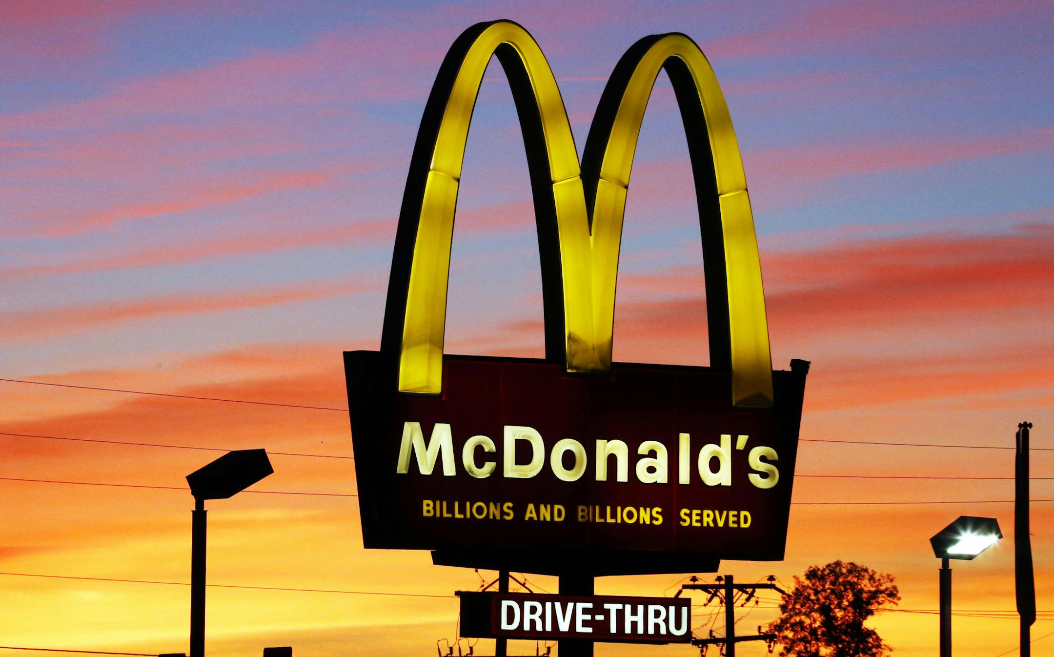 FILE - In this Saturday, Oct. 10, 2015 file photo, the sun sets behind a McDonald's restaurant in Ebensburg, Pa. On Tuesday, Jan. 12, 2016 the European Union said it will analyze an antitrust complaint targeted at the McDonaldís which accuses the fast food giant of abusing its dominant position by at the expense of both its franchisees and consumers. The complaint comes on top of last monthís opening of an EU investigation whether McDonald's received a sweet tax deal from Luxembourg. (