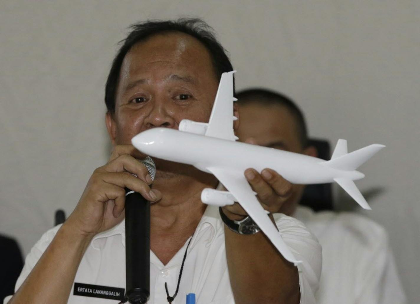 Indonesian National Transportation Safety Committee (KNKT) investigator Ertata Lananggalih holds a model plane as he explains the movement of AirAsia Flight 8501 before it crashed into the Java Sea.