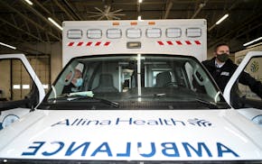 Paramedic Josh Anderson, right, and EMT Ryan Vierzba prepare to depart in their ambulance for a shift in February 2022 at the Allina Health EMS South 