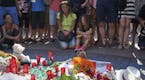 People gather at a makeshift memorial on Las Ramblas, where the day before a van attack killed 13 people on the busy main street, in Barcelona, Spain,