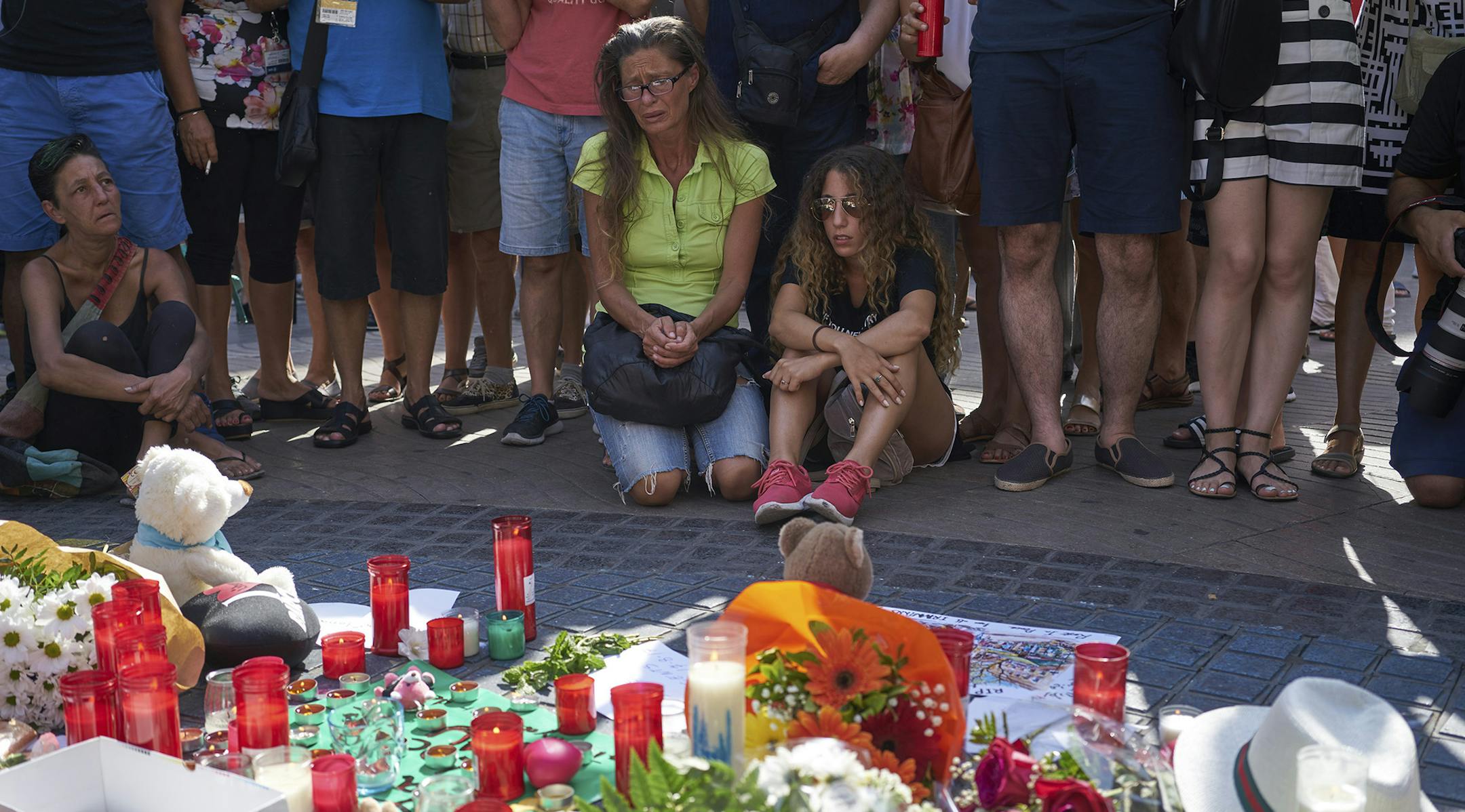 People gather at a makeshift memorial on Las Ramblas, where the day before a van attack killed 13 people on the busy main street, in Barcelona, Spain, Aug. 18, 2017. Two vehicle assaults, in Barcelona and a seaside resort town, came after the Spanish authorities had been warning of an impending attack for some time. The Islamic State claimed responsibility for the attack in Barcelona. (Samuel Aranda/The New York Times) ORG XMIT: MIN2017081812530517