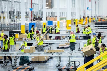 Employees at Amazon’s sorting center in Woodbury last week. Amazon opened the 525,000-square-foot building, visible from Interstate 94, in August.