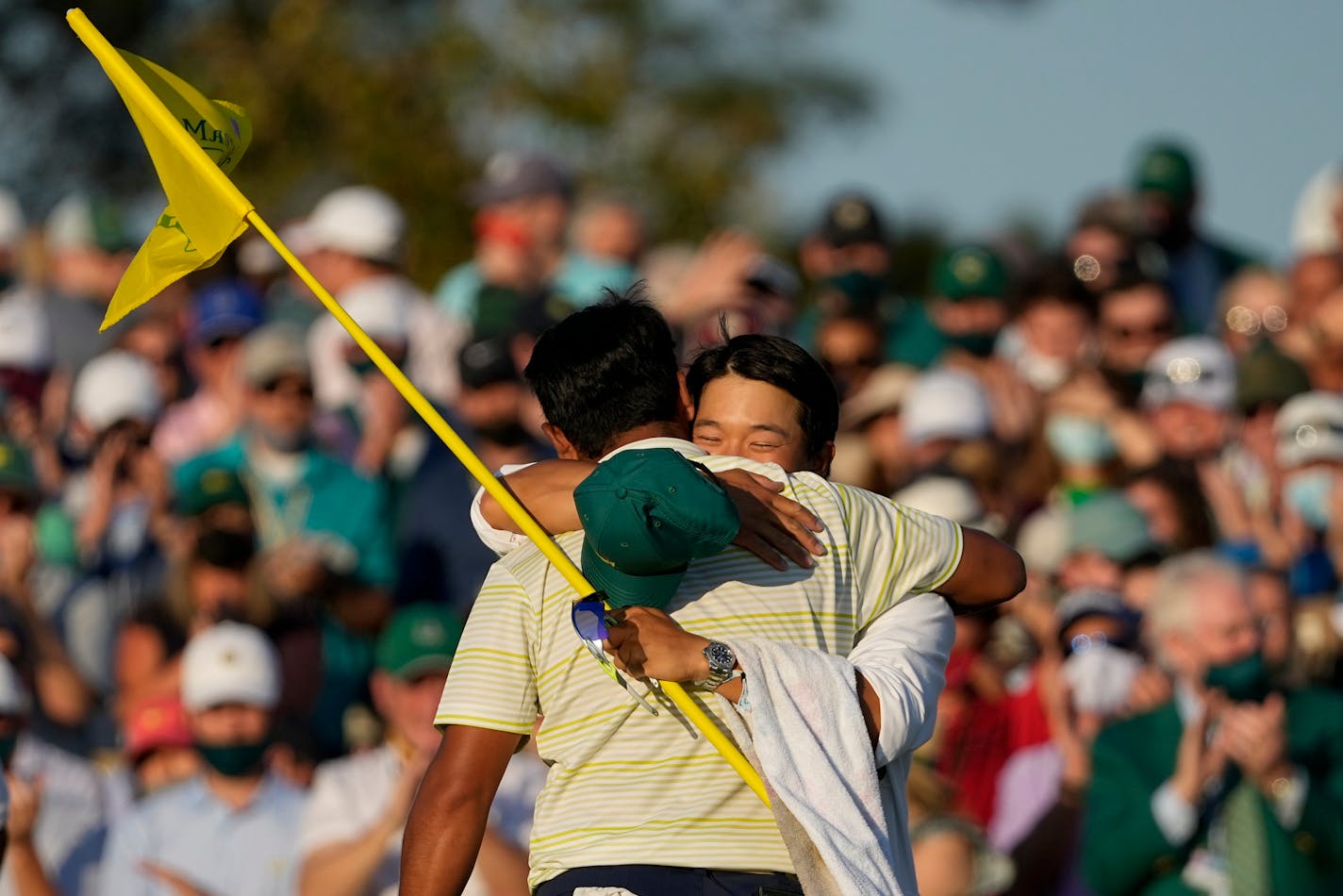 Hideki Matsuyama, of Japan, hugs his caddie Shota Hayafuji after winning the Masters golf tournament on Sunday, April 11, 2021, in Augusta, Ga. (AP Photo/Charlie Riedel)