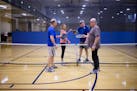 Ted Peters, from left, Becky Zech, Doug Steele and Dennis Newton tap their paddles after finishing a game of pickleball on Feb. 23 at the Eagan Commun