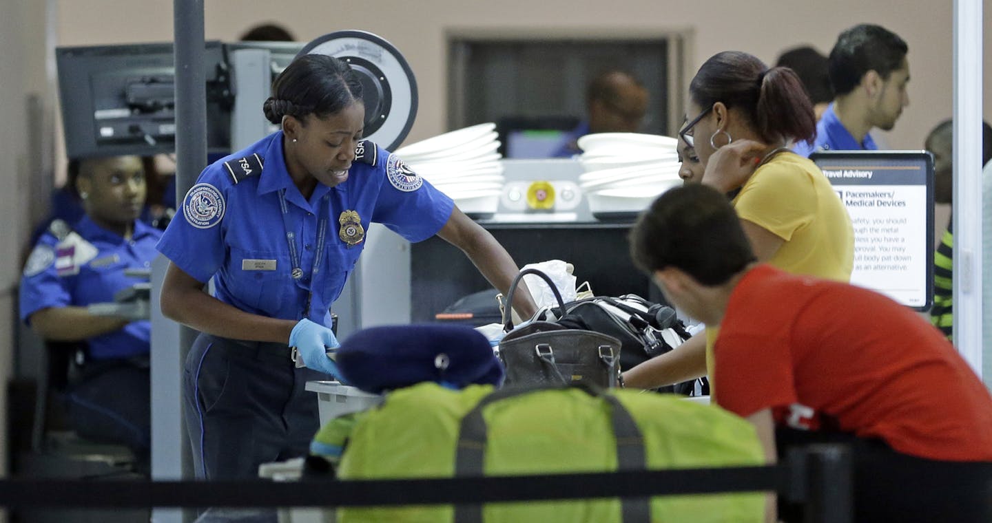 A Transportation Security Administration officer checks travelers luggage to be screened by an x-ray machine at a checkpoint at Fort Lauderdale-Hollywood International Airport, Friday, May 27, 2016, in Fort Lauderdale, Fla. Memorial Day weekend, the unofficial start of summer vacations for many and a busy travel period, serves as a crucial test for the TSA. (AP Photo/Alan Diaz)