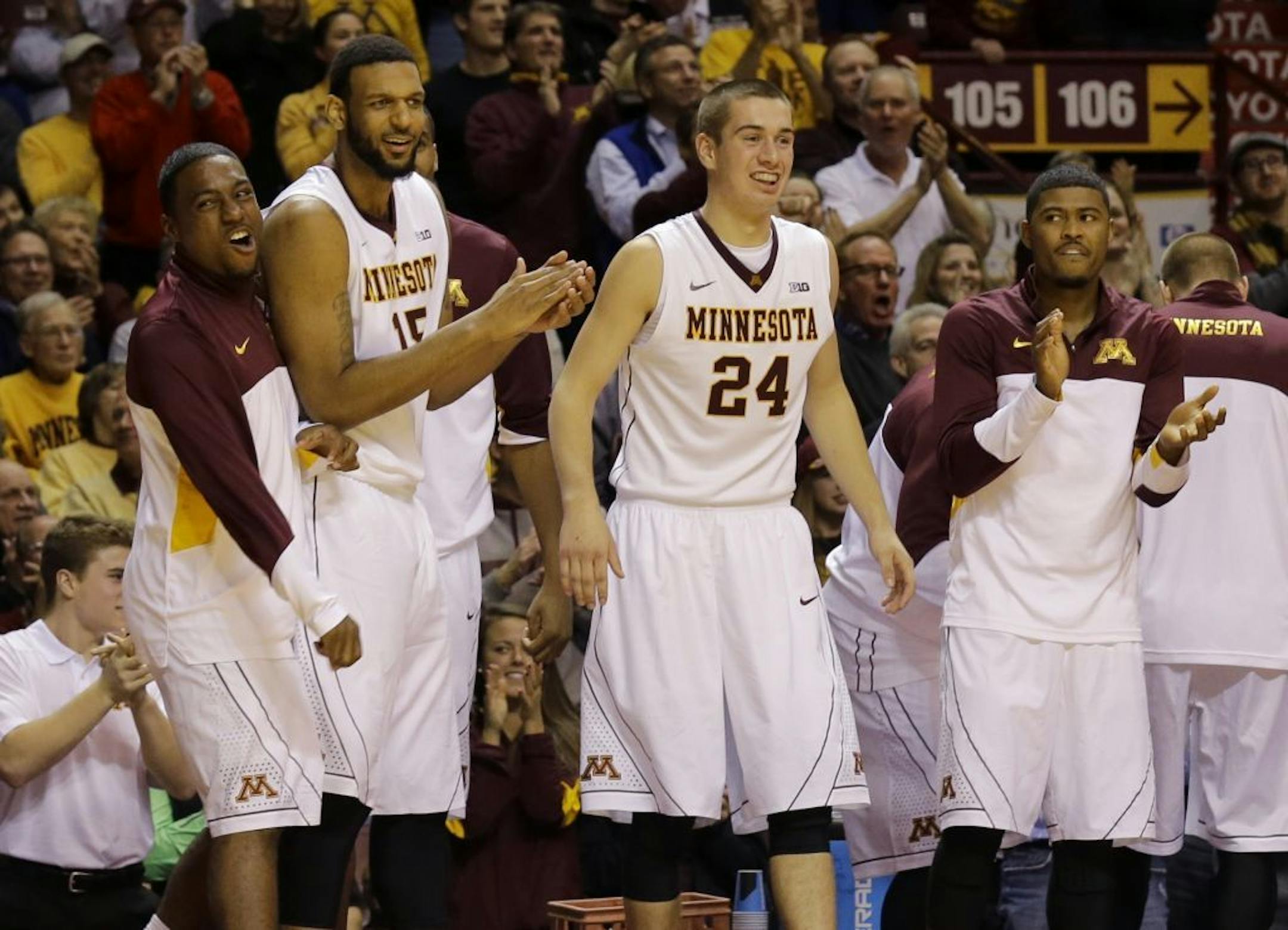 Minnesota guard Kendal Shell, left, forward Maurice Walker (15), forward Joey King (24) and guard Maverick Ahanmisi, right, cheer from the bench during the second half of an NCAA college basketball game against Florida State in Minneapolis, Tuesday, Dec. 3, 2013. Minnesota beat Florida State 71-61.