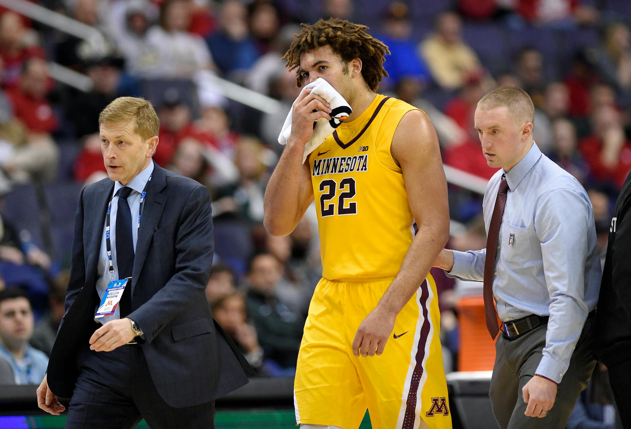 Gophers center Reggie Lynch was escorted to the bench after he took an elbow to the mouth during the second half against Michigan State.
