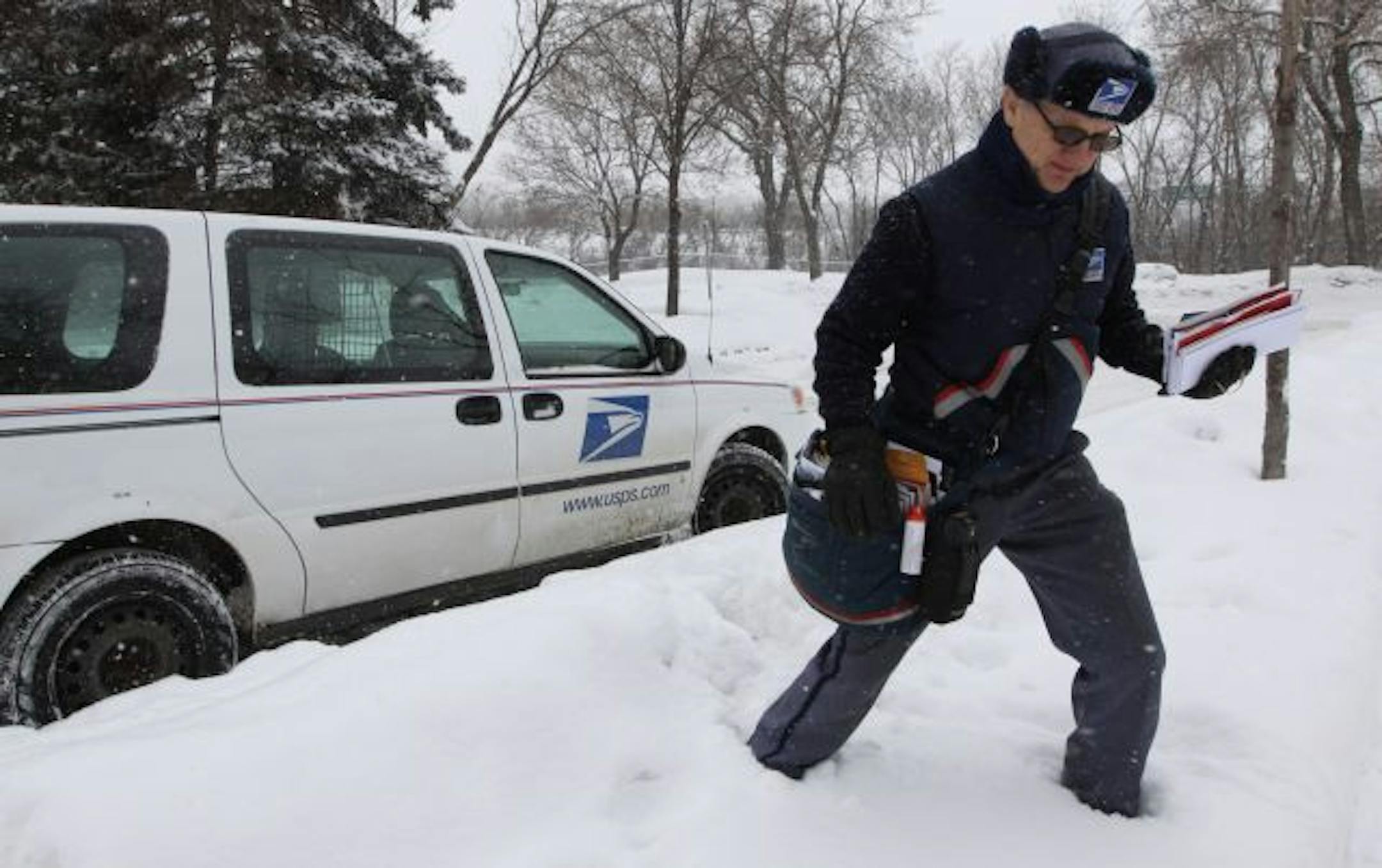 U.S. Post Office Mail Carrier Kiernan Hughes climbed over and through piles of snow to deliver mail near East Franklin and 31st Ave in Minneapolis.