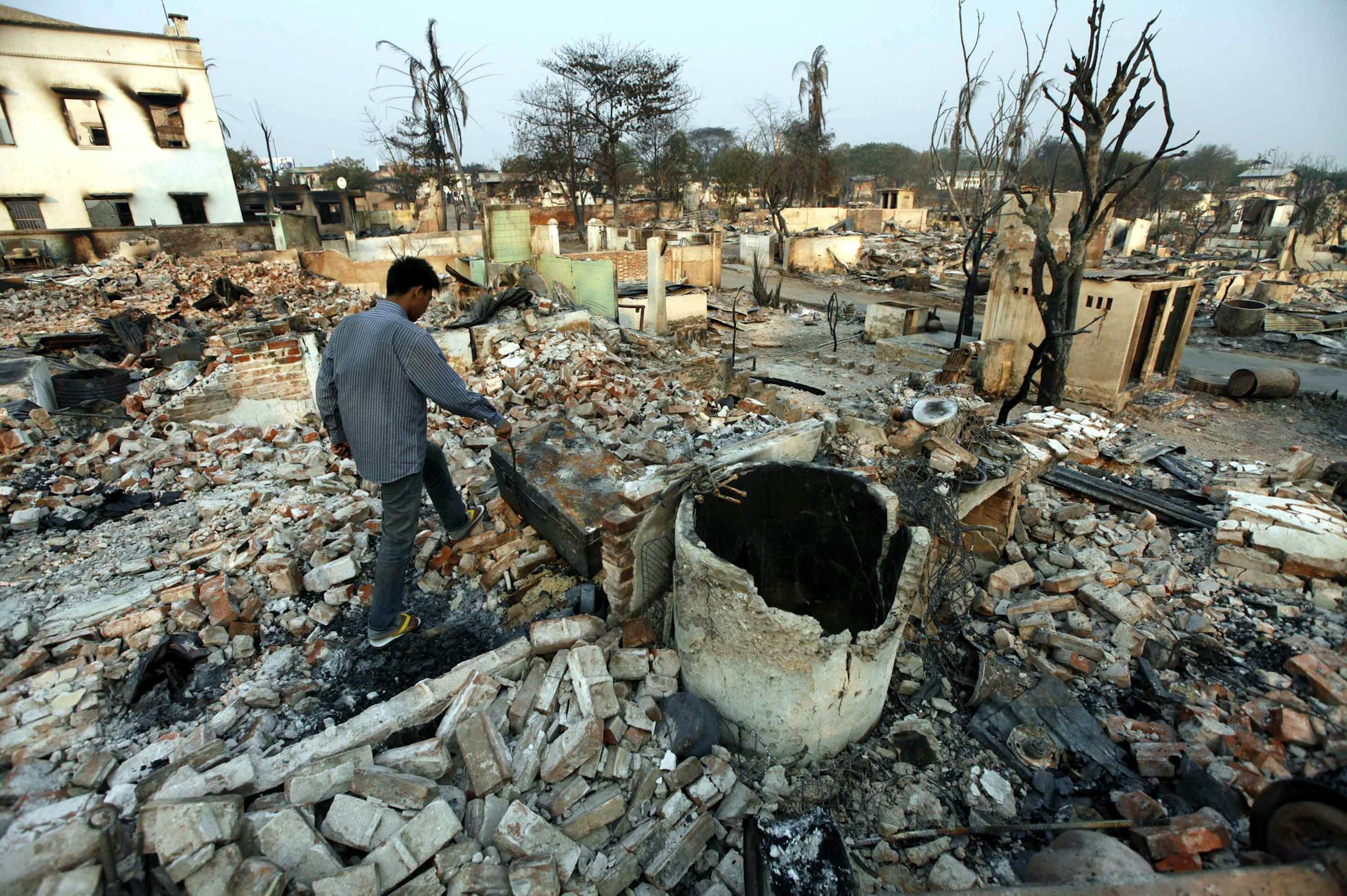 A man walks among debris of buildings destroyed during ethnic unrest between Buddhists and Muslim in Meikhtila, about 550 kilometers (340 miles) north of Yangon, Myanmar, Monday, March 25, 2013. Sectarian clashes between Buddhists and Muslims in Meikhtila spread to at least two other towns in the country's heartland over the weekend, undermining government efforts to quash an eruption of violence that has killed dozens of people and displaced 10,000 more. On Sunday, Vijay Nambiar, the U.N. secre