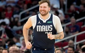 Dallas Mavericks guard Luka Doncic smiles after making a basket against the Houston Rockets during the second half of an NBA basketball game Sunday, M