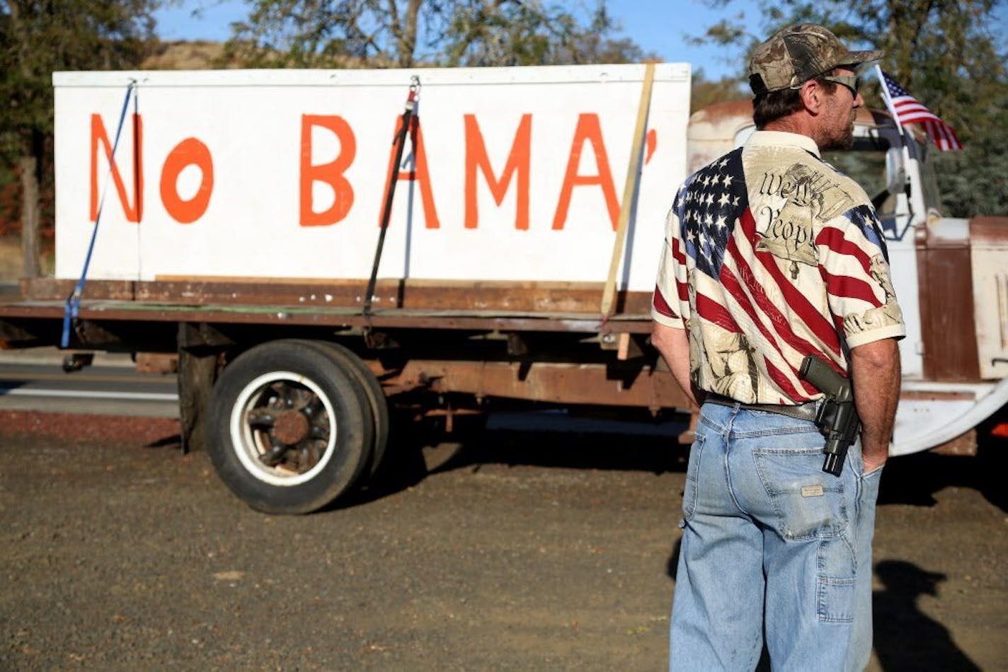 Michael Johnson waits outside of Roseburg Municipal Airport for President Barack Obama's arrival in Roseburg, Ore., Friday, Oct. 9, 2015.