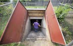 Natividad Seefeld climbs down into her neighborhood's current, cramped storm shelter as the mobile home park awaits its new shelter's groundbreaking t