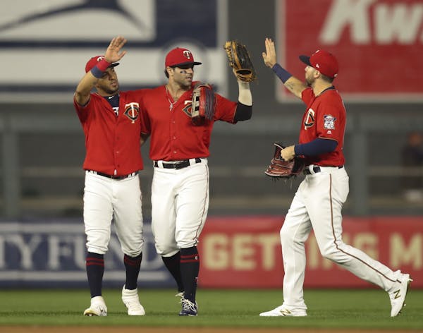 Minnesota Twins left fielder Eddie Rosario, center fielder LaMonte Wade Jr., and right fielder Jake Cave, from left, celebrated after the Twins win.