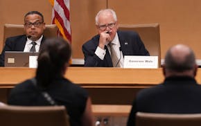 Attorney General Keith Ellison and Gov. Tim Walz listen during a Board of Pardons meeting in 2023 at the Minnesota Senate Building in St. Paul.