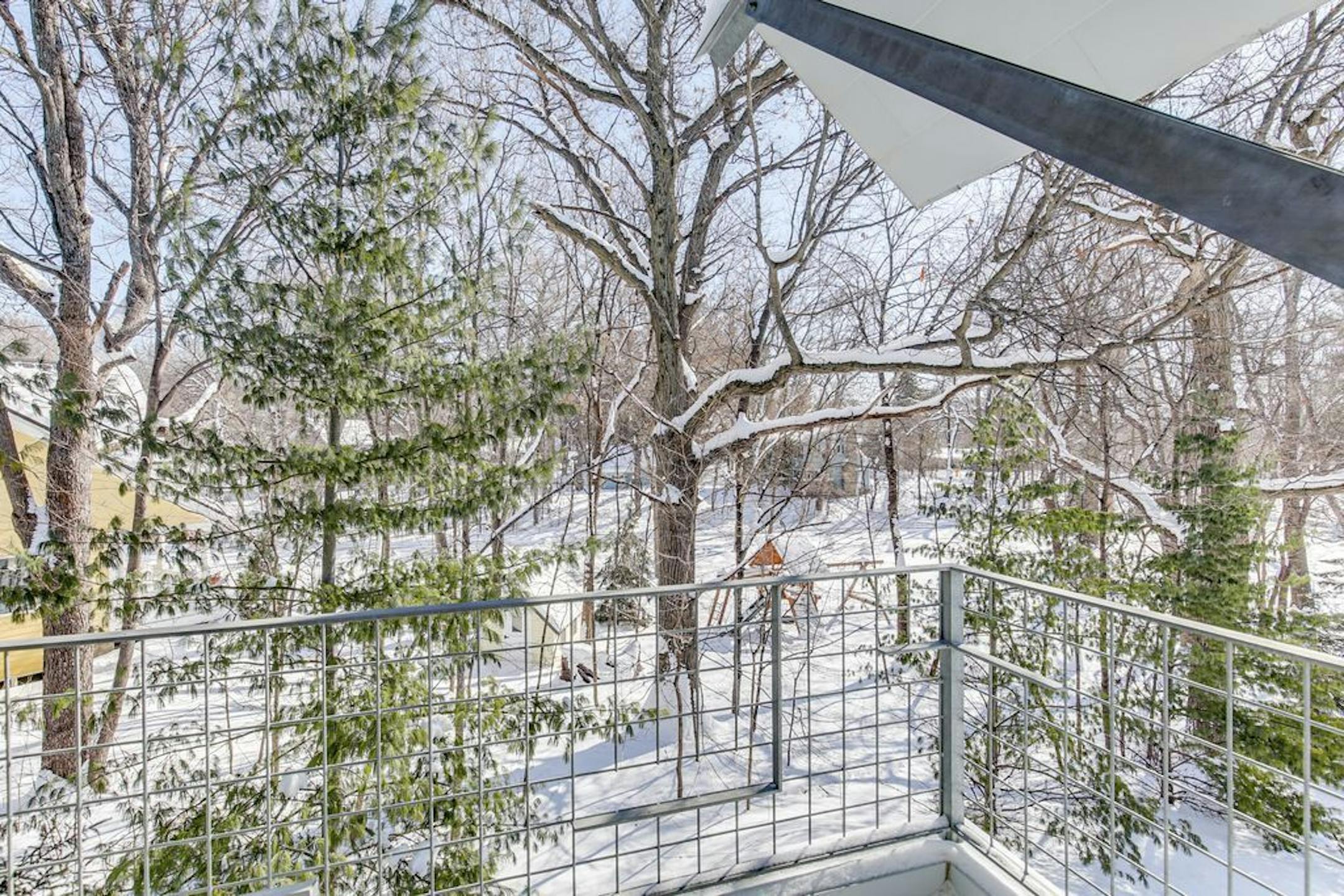 The view from a deck into the wooded backyard.