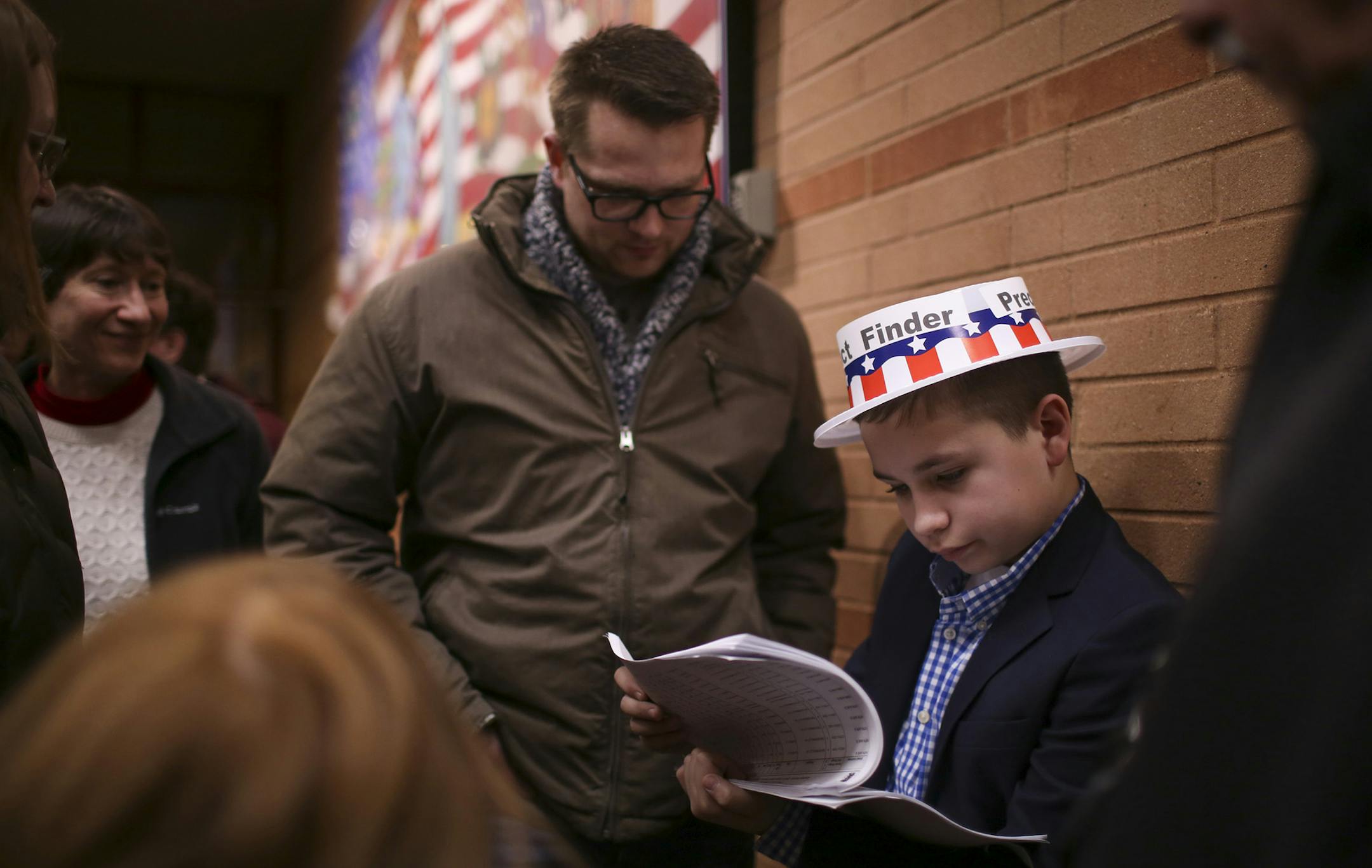 Volunteer precinct finder Keaton Leithead, 13, directs Republican voters to their caucuses at Black Hawk Middle School, Tuesday, March 1, 2016, in Eagan, Minn. Voters from Vermont to Colorado, Alaska to American Samoa and a host of states in between took to polling places and caucus sites Tuesday, on the busiest day of the 2016 primaries. (Jeff Wheeler/Star Tribune via AP) MANDATORY CREDIT; ST. PAUL PIONEER PRESS OUT; MAGS OUT; TWIN CITIES LOCAL TELEVISION OUT ORG XMIT: MIN2016030212363637