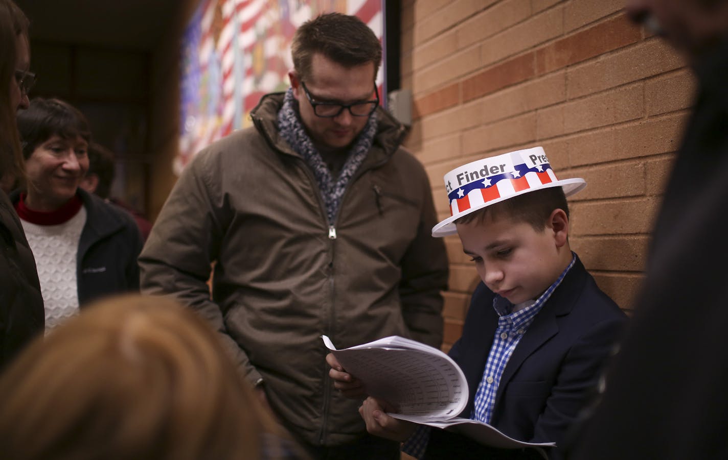 Volunteer precinct finder Keaton Leithead, 13, directs Republican voters to their caucuses at Black Hawk Middle School, Tuesday, March 1, 2016, in Eagan, Minn. Voters from Vermont to Colorado, Alaska to American Samoa and a host of states in between took to polling places and caucus sites Tuesday, on the busiest day of the 2016 primaries. (Jeff Wheeler/Star Tribune via AP) MANDATORY CREDIT; ST. PAUL PIONEER PRESS OUT; MAGS OUT; TWIN CITIES LOCAL TELEVISION OUT ORG XMIT: MIN2016030212363637