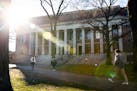 People walk past the Widener Library at Harvard University in Cambridge, Mass., in December 2023.