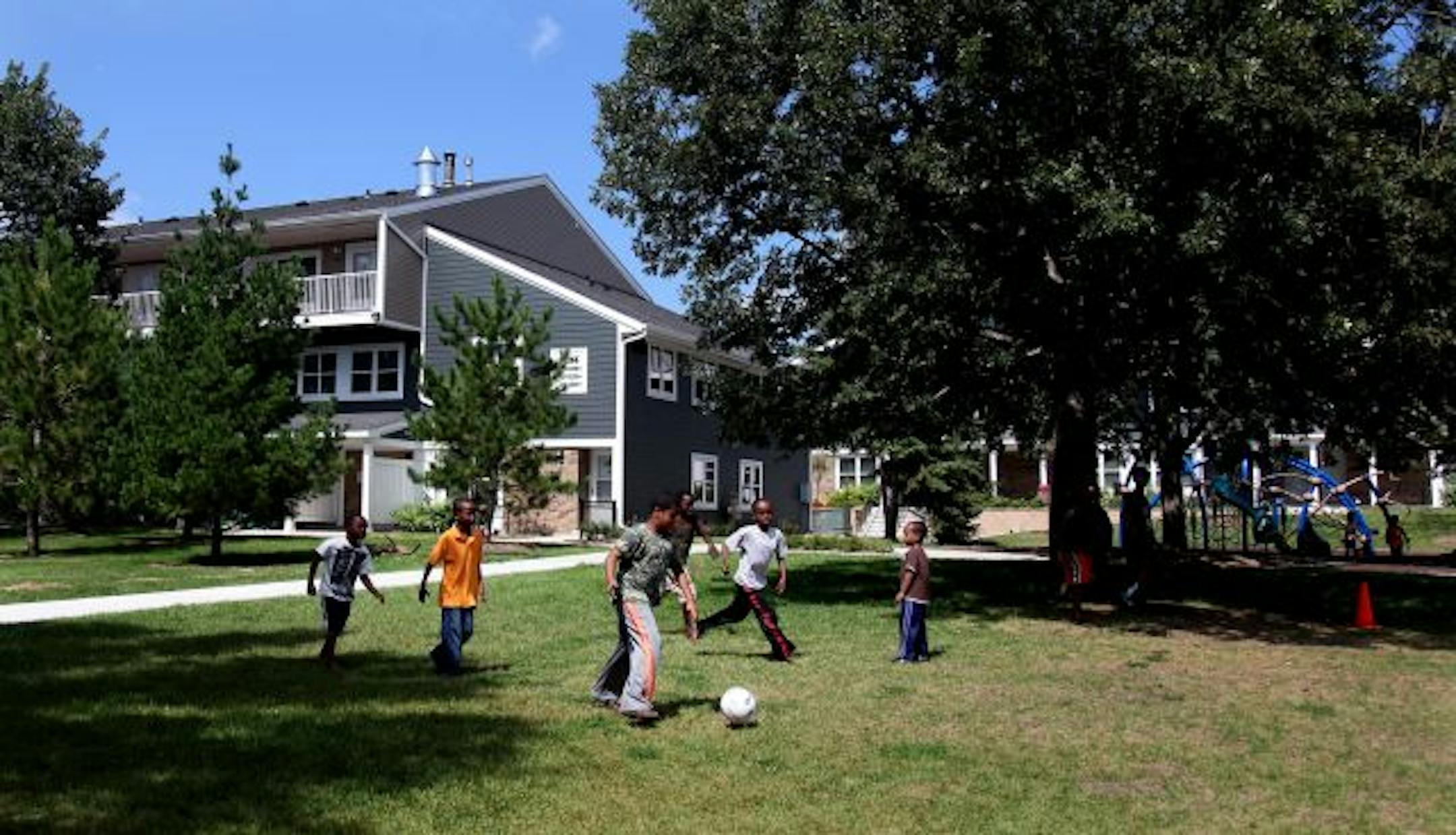 Children played soccer outside a newly renovated courtyard at the Chancellor Manor pubic housing development.
