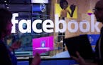 FILE - In this April 18, 2017, file photo, conference workers speak in front of a demo booth at Facebook's annual F8 developer conference, in San Jose
