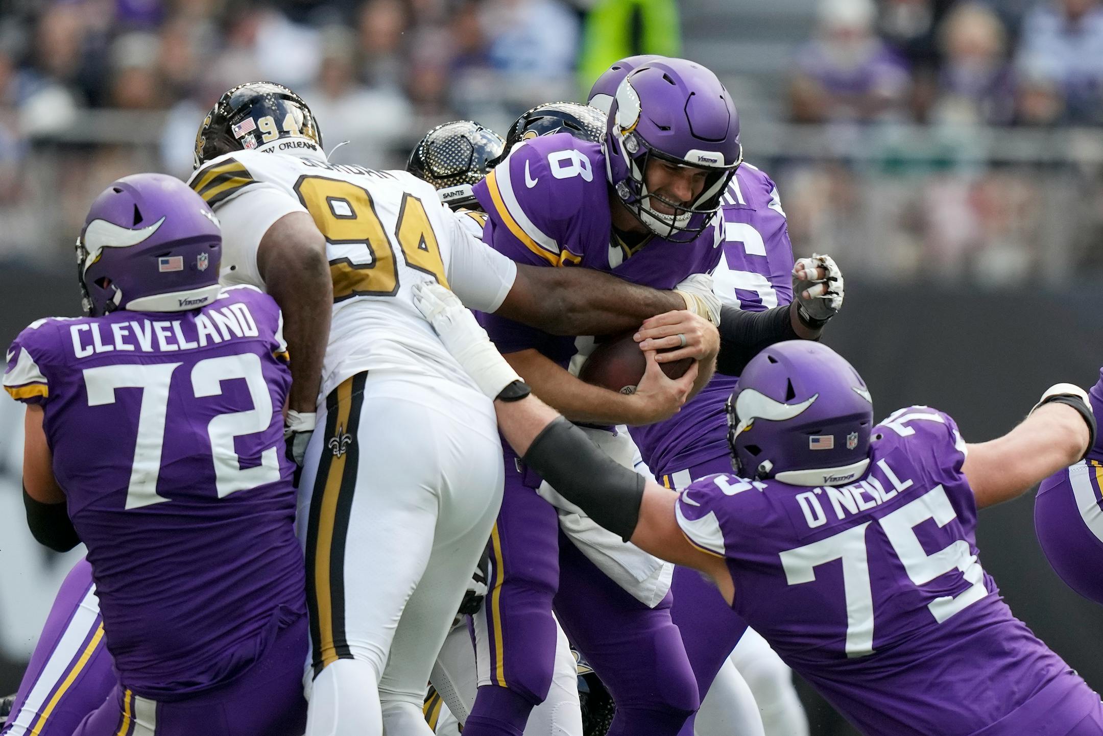 Minnesota Vikings quarterback Kirk Cousins (8), center, is sacked.