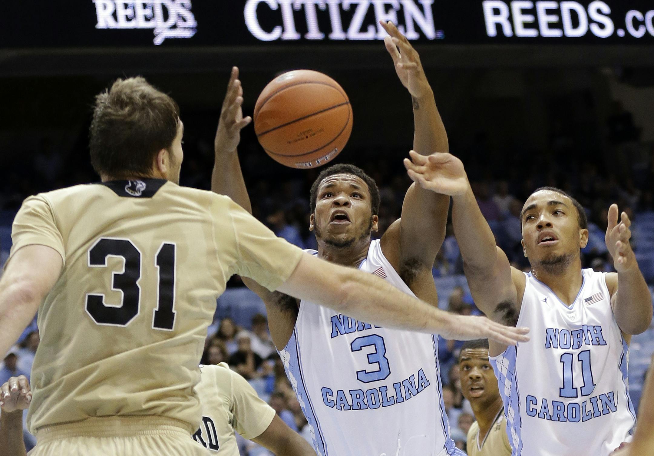 North Carolina's Kennedy Meeks (3) and Brice Johnson (11) reach for a rebound with Wofford's C.J. Neumann (31) during the first half of an NCAA college basketball game in Chapel Hill, N.C., Wednesday, Nov. 18, 2015. (AP Photo/Gerry Broome)