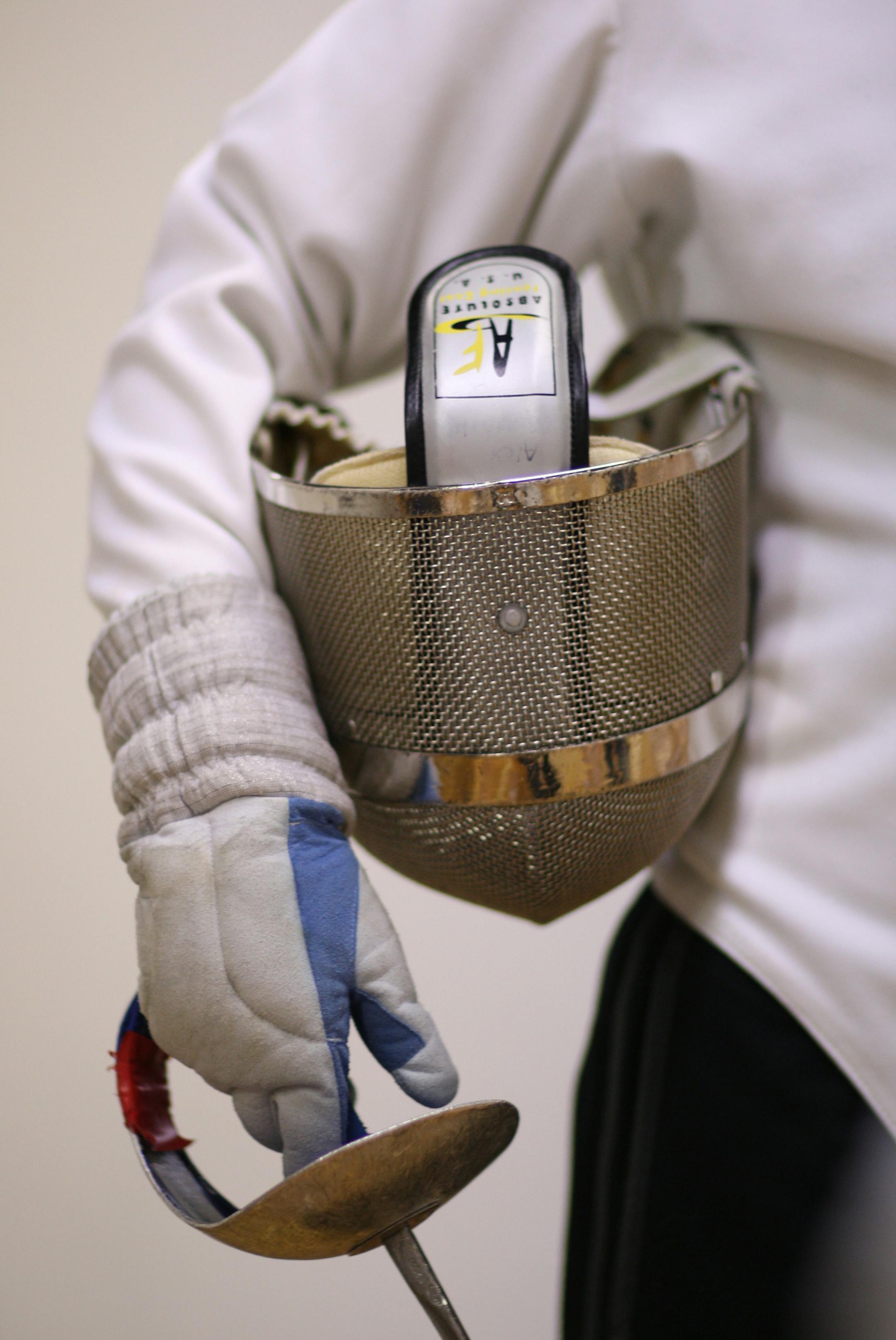 A saber and a protective mask were held by a class participant Thursday night at the Minnesota Sword Club.