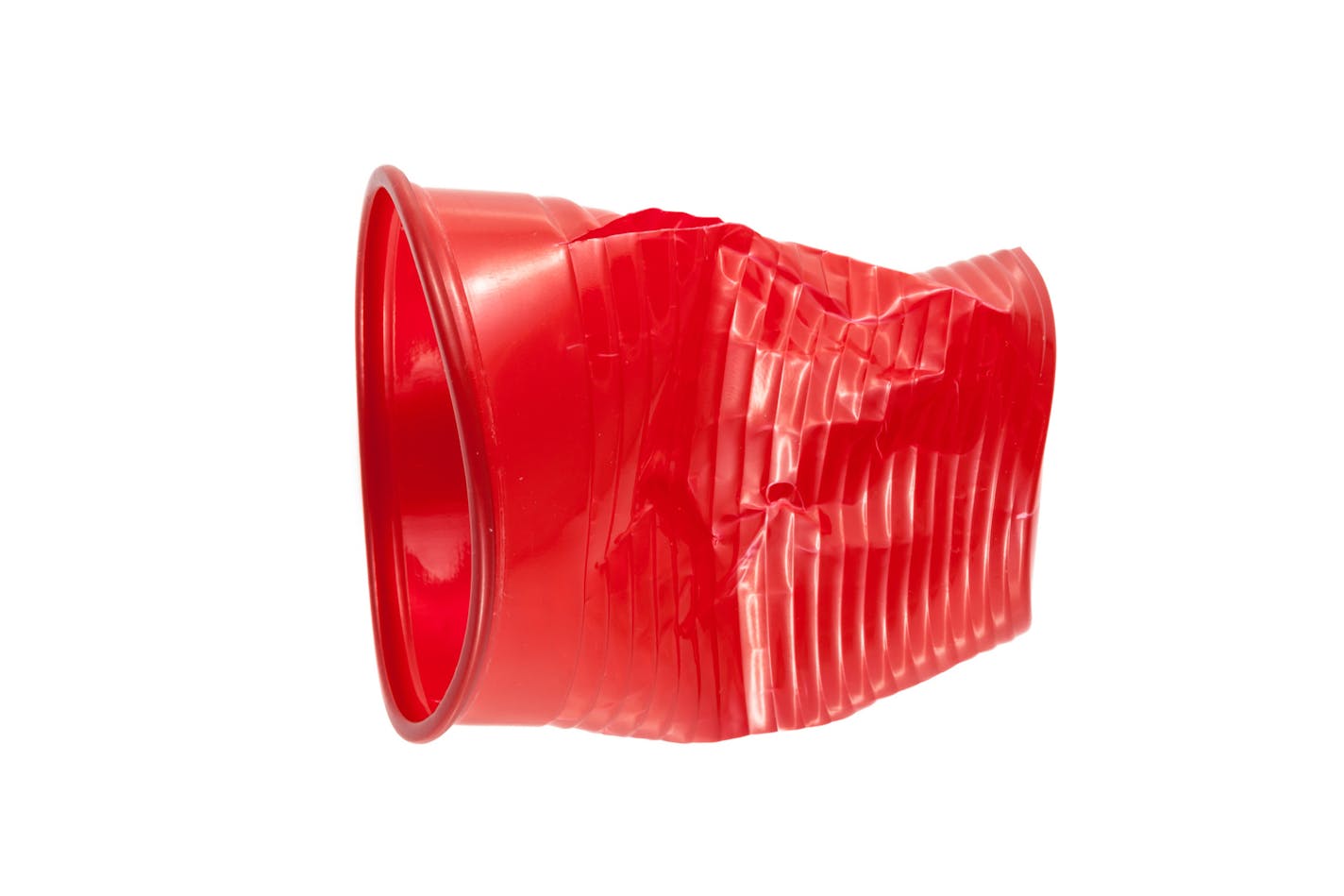 Crushed red plastic cup on a white background