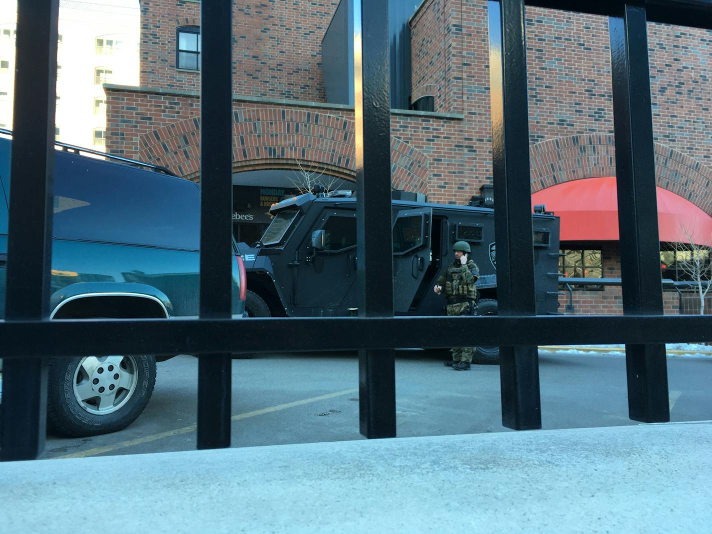 A Minneapolis police officer in tactical gear stands outside the Graduate Hotel, where a man has been involved in a standoff with officers for hours. -Karen Zamora