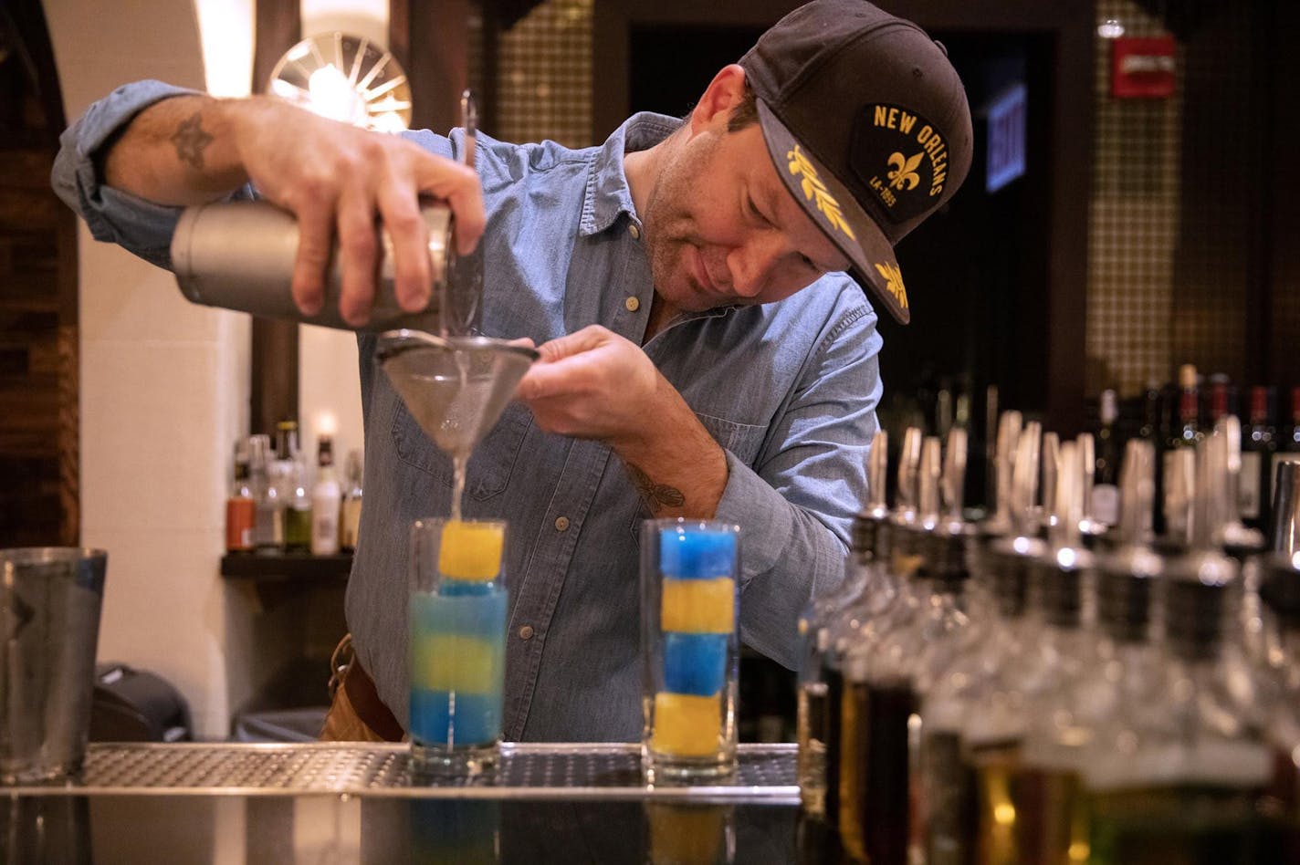 Bar manager Derek Alexander mixes an Andy Warhol-inspired "Orange Prince" cocktail, a drink make with gin, grapefruit, St. Germain, curacao and Bolivar bitters at the Berkshire Room inside the Acme Hotel in Chicago on October 30, 2019, in Chicago. A popup hotel room within the Acme Hotel is also decorated with Andy Warhol-themed decor. (Erin Hooley/Chicago Tribune/TNS)