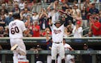 Minnesota Twins designated hitter Robbie Grossman (36) signals to Minnesota Twins center fielder Jake Cave (60) he had clear sailing to home after sho