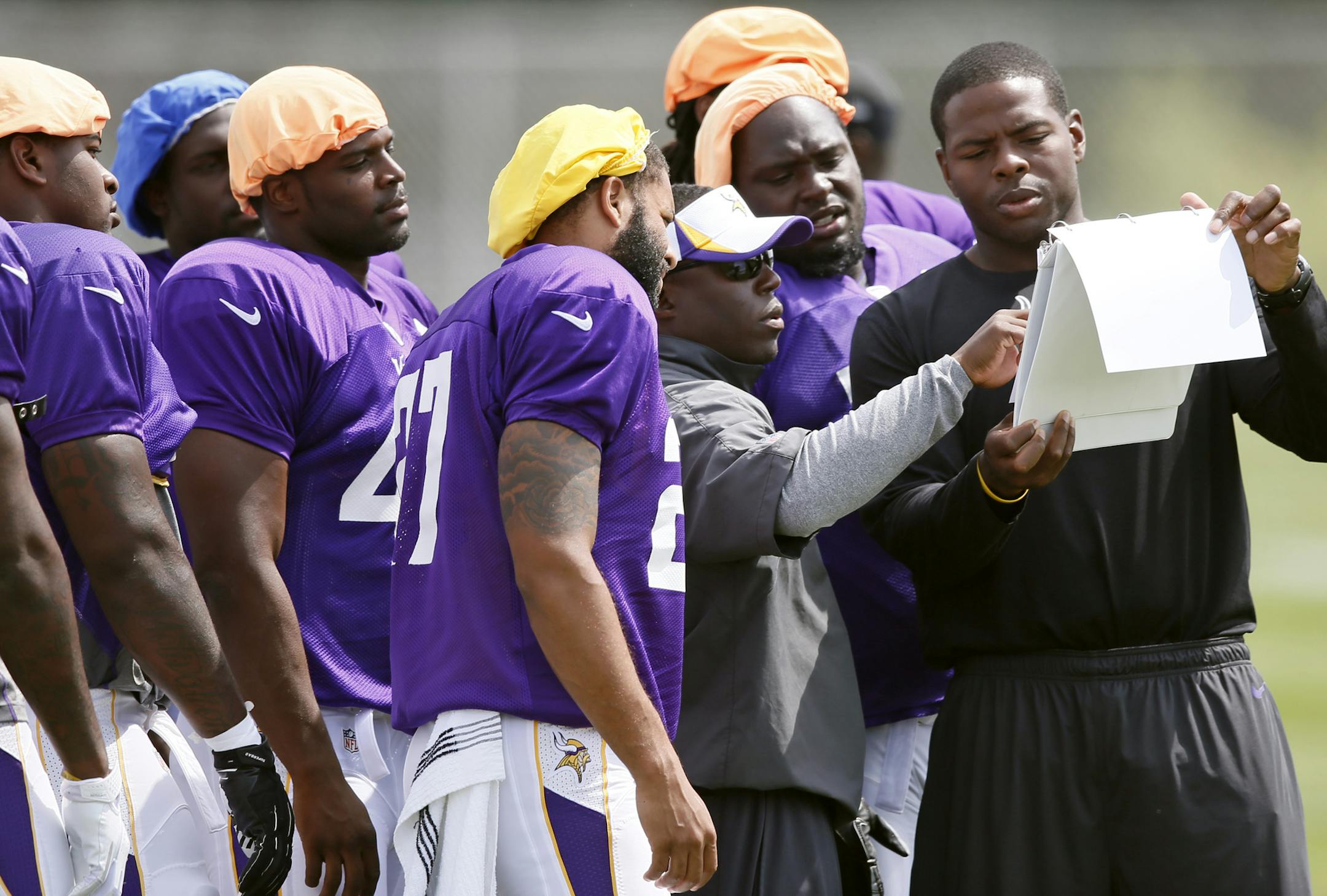 Vikings former defensive end Kenechi Udeze right an intern with the team held a play book for Alan Williams (defensive coordinator) during Vikings practice at Minnesota State University Mankato Wednesday Aug 14 ,2013 in Mankato, MN. ] JERRY HOLT &#x201a;&#xc4;&#xa2; jerry.holt@startribune.com