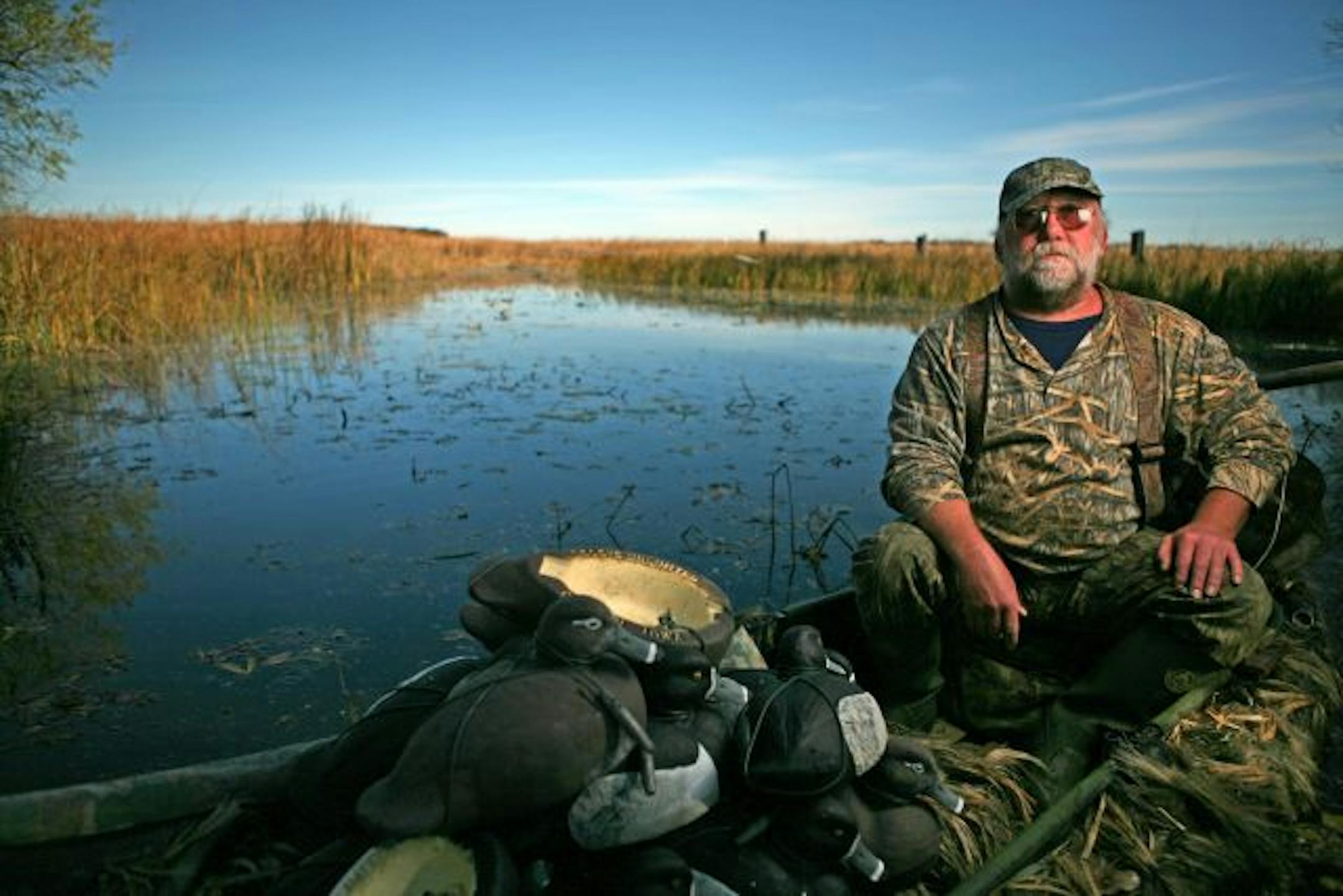 Bill Gombold has put his family's 45 acres in East Bethel, adjacent to Deer Lake, into an conservation easement, which means that for perpituity it can't be developed or changed in a way that is harmful to the ecosystem there. IN THIS PHOTO: Gombold's duck-hunting buddy Rick Gehrman sits in his duck boat loaded with decoys. Gehrman spent the morning on Deer Lake duck hunting as he often does during the week. He has been duck hunting on Deer Lake and with Gombold for 35 years.
