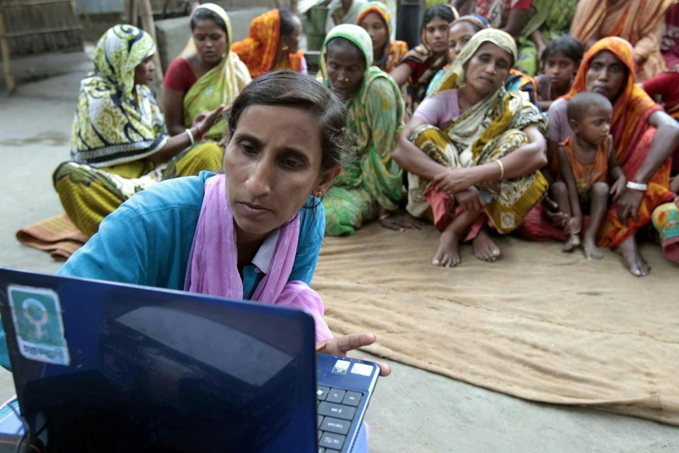 In this Sept. 30, 2012 photo, Sathi Akhtar, a 29-year-old Bangladeshi woman known as Tattahakallayani or Info Lady shows a 15-minute video played in a laptop at one of their usual weekly meetings at Saghata, a remote impoverished farming village in Gaibandha district, 120 miles (192 kilometers) north of capital Dhaka, Bangladesh. Dozens of �Info Ladies� bike into remote Bangladeshi villages with laptops and Internet connections, helping tens of thousands of people - especially women - get everyt