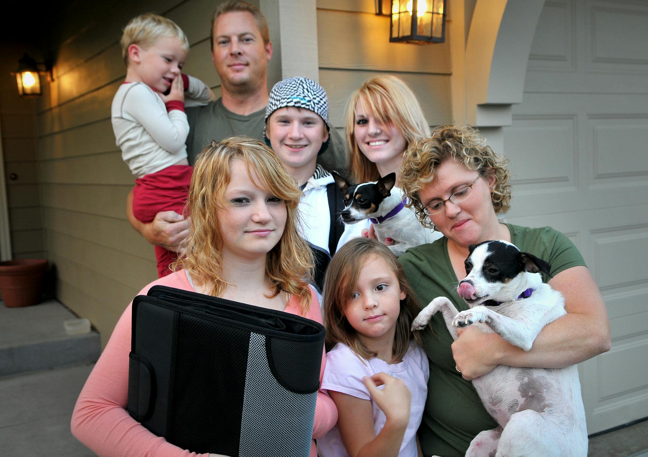 The Exline family with Nelson kids Tuesday morning in front of their Lakeville home, before they headed off to the first day of school, front row. l to r, Dylan Nelson, 13, Taylor Exline, 8, Michelle Exline, holding Tallulah. Back row Ben Exline, 4 1/2, Joel Exline, Zack Nelson, 15, and Kelsey Exline, 18. Missing was Maddie Exline, 19. Anne Hendrickson Nelson died of cancer, six months after her husband, Graig, (also died of cancer. They left behind two children. Anne's best friend and her husba