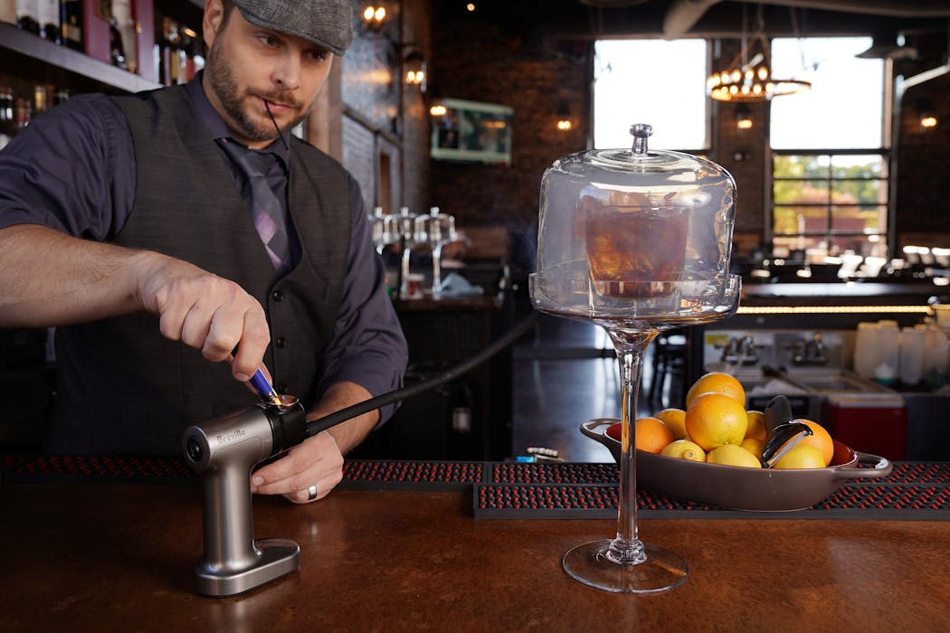 Brick & Bourbon owner Gary Sivyer used a smoking gun to make a Maple Old Fashioned cocktail.