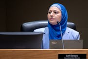 Lori Saroya, shown in a blue suit and hijab, takes her seat after being sworn in as the Ward 1 City Council Member Wednesday, January 4, 2023, in Blai