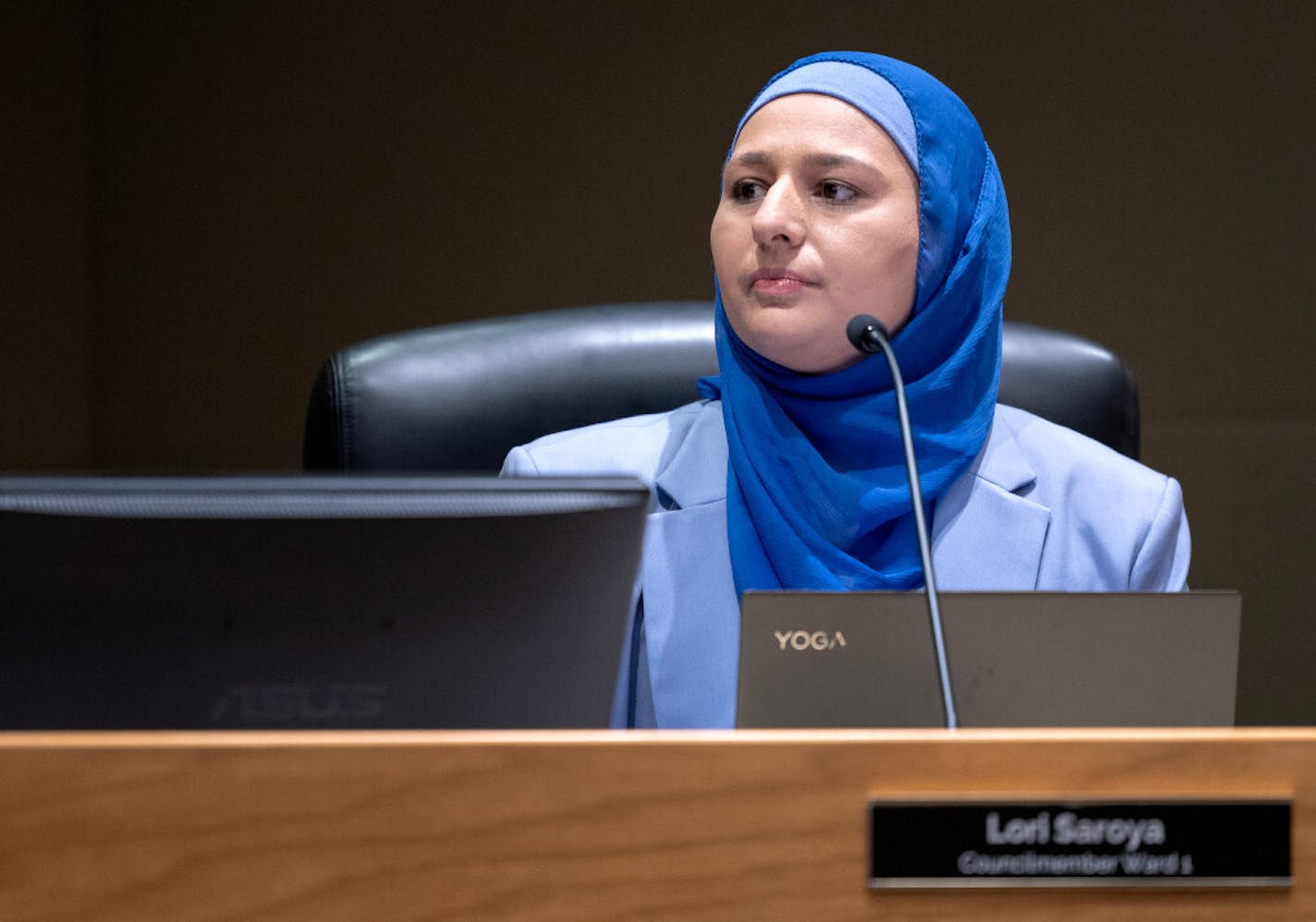 Lori Saroya, shown in a blue suit and hijab, takes her seat after being sworn in as the Ward 1 City Council Member Wednesday, January 4, 2023, in Blaine, Minn.