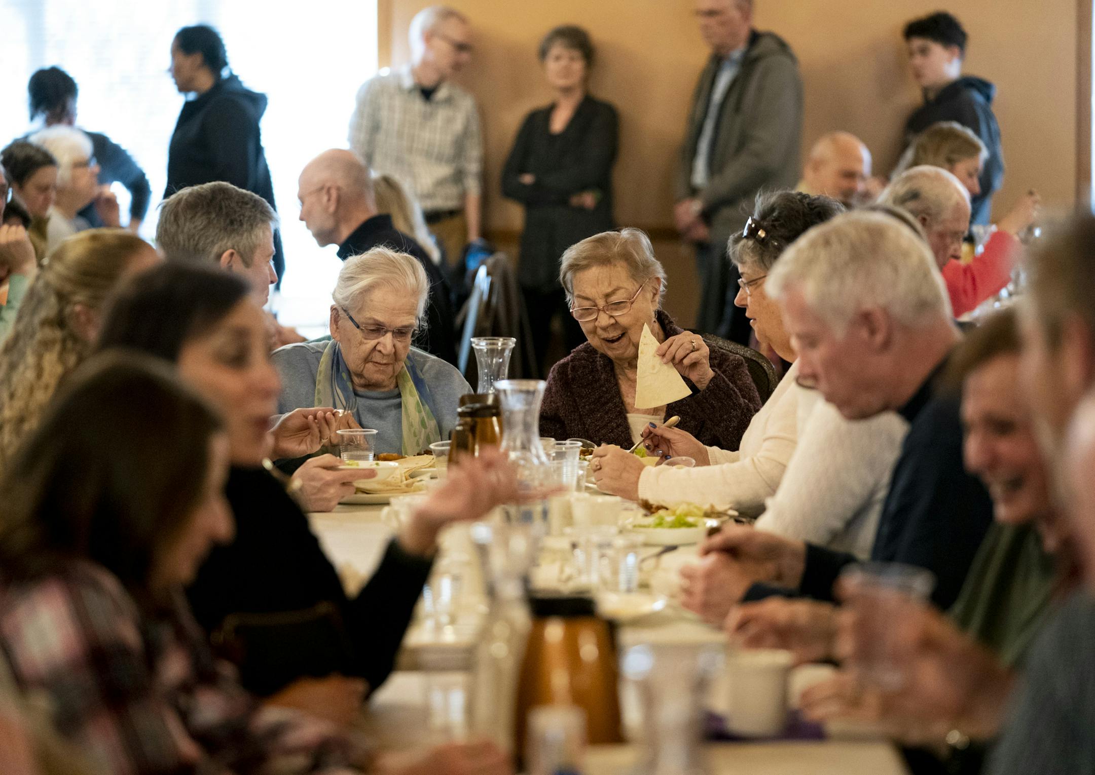 Marilyn Carnes and Karin McComb enjoyed a meal at the Friday Fish Fry at Holy Family Maronite Catholic Church in Mendota Heights, Minn., on Friday, March 22, 2019. They do not go to this church but they came for the famous Lebanese style fish fry. McComb is holding traditional Lebanese flatbread. The entire church was packed with people eating and doing lines. The church is a Lebanese Catholic Church. Most of the families are second or third generation Lebanese Americans. ] RENEE JONES SCHNEIDER