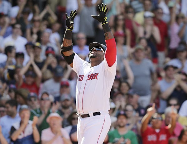 Boston Red Sox designated hitter David Ortiz raises his arms as he crosses home plate after his game-tying, solo home run during the 10th inning of a 