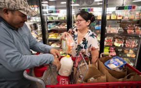 Chris and Antonia Ramirez pick up some grocery items for their family of four at the Open Door food pantry in Eagan on May 15.