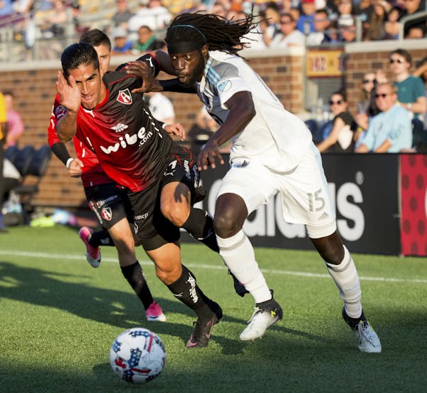 Minnesota United's Ismaila Jome, right, and Atlas' Jose Maduena vie for the ball during the first half ofan international friendly soccer match Saturd