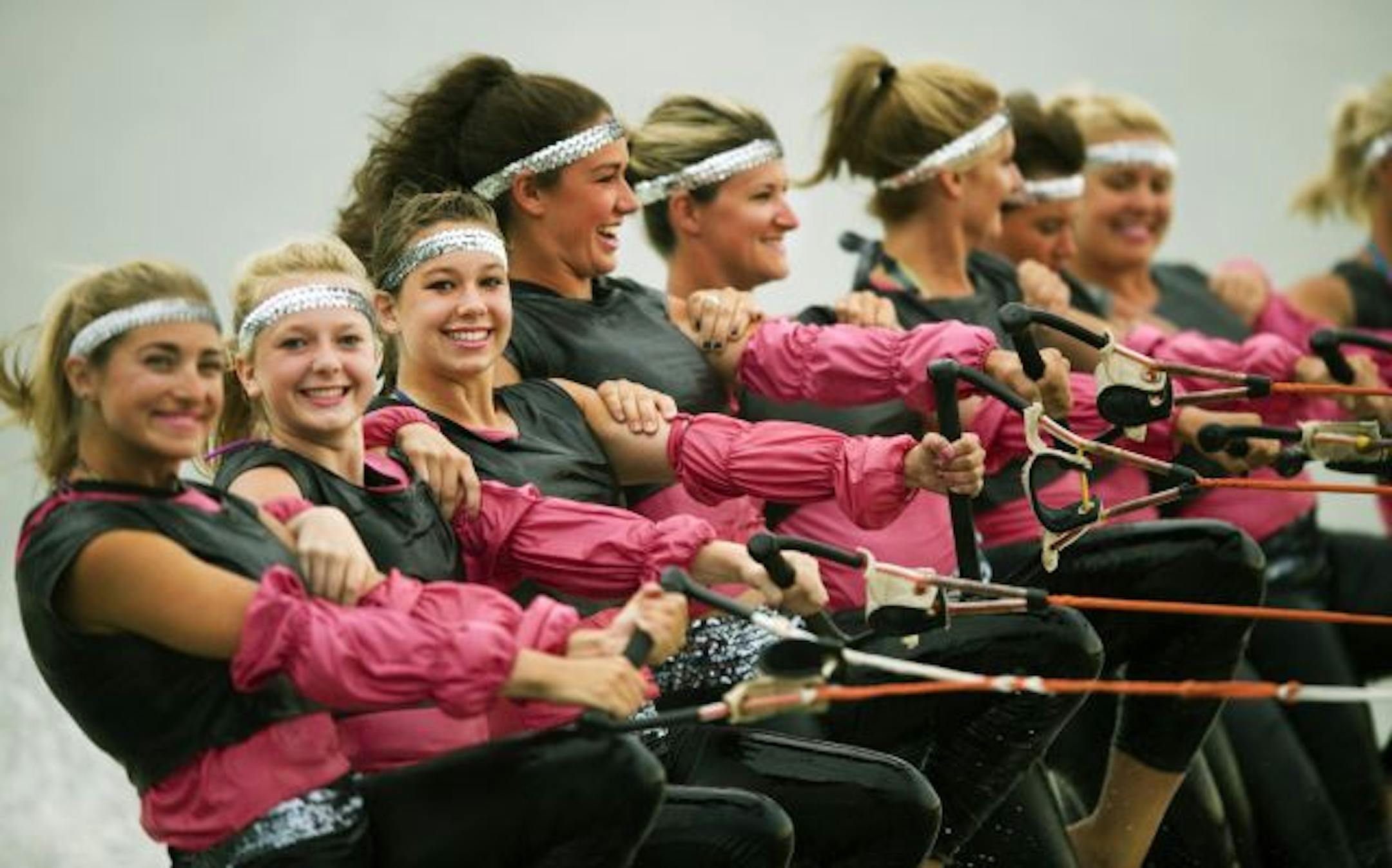 Members of a water ski ballet line take off simultaneously from the dock.