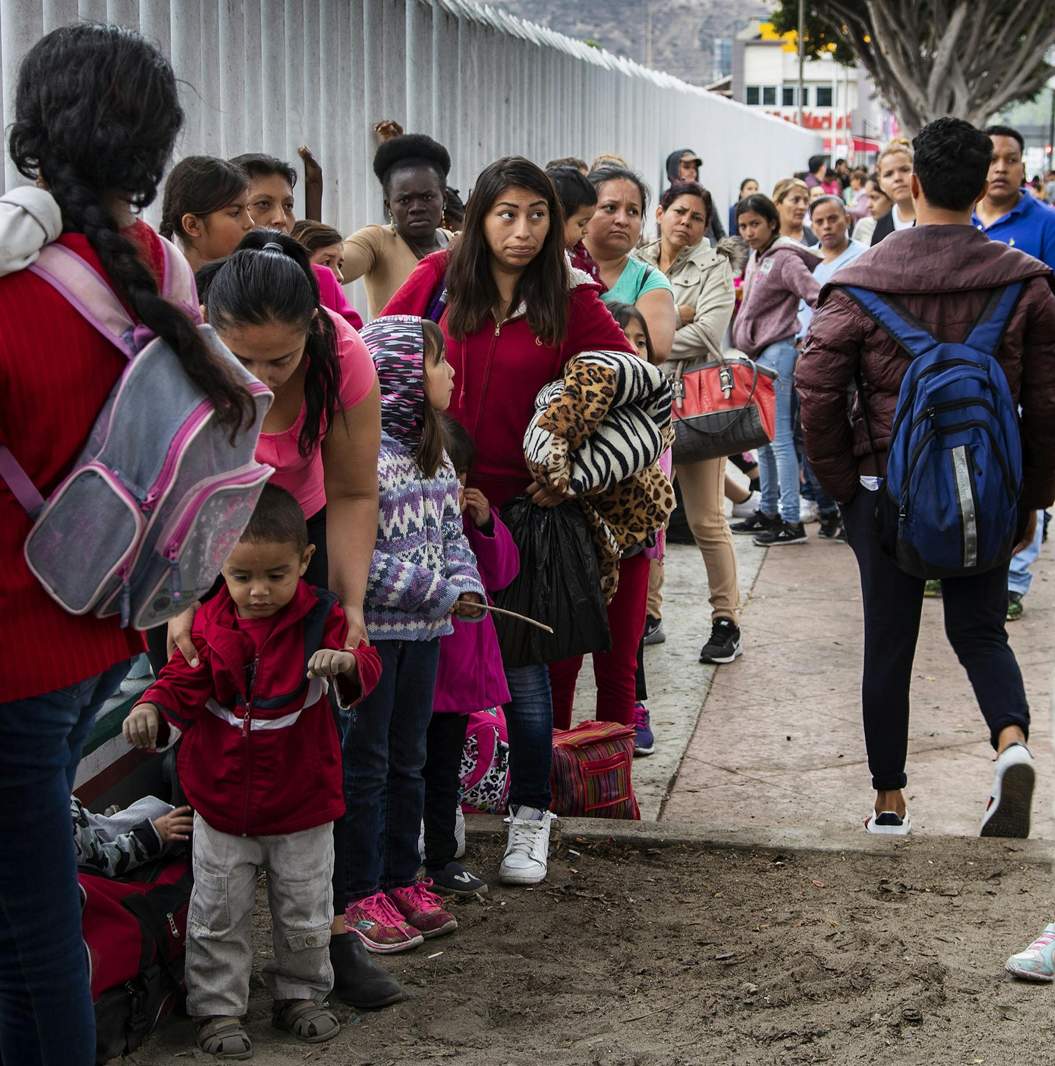 Asylum-seeking immigrants line up at a border fence in Tijuana, Mexico on June 20, 2018. (Gina Ferazzi/Los Angeles Times/TNS)